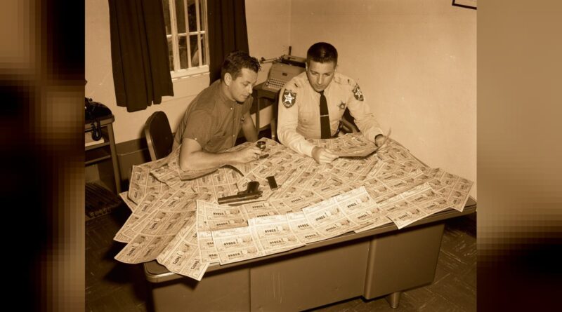 A Monroe County Deputy looking at fake Cuban lottery tickets C 1960.